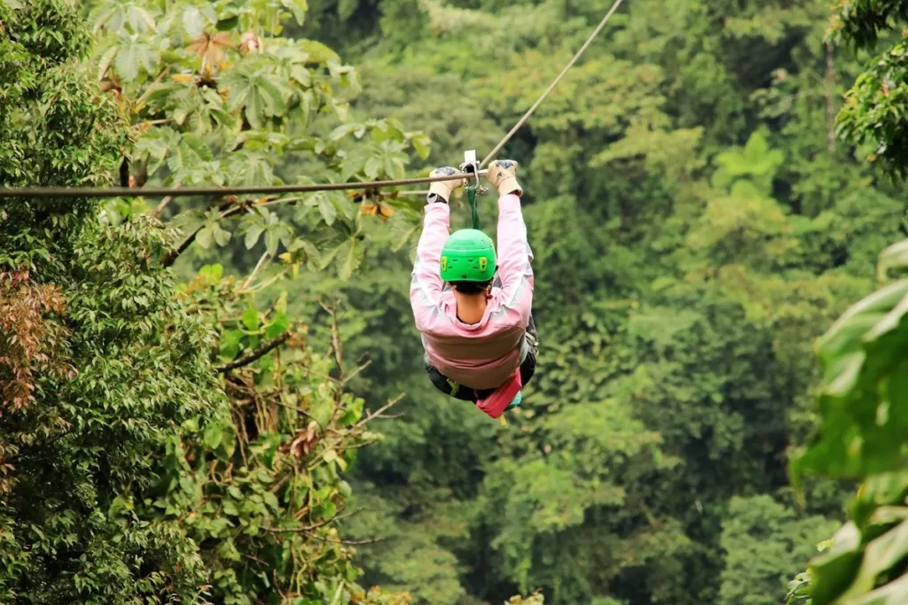 A person in safety gear ziplining through the lush jungle canopy during an exhilarating canopy tour in Costa Rica.